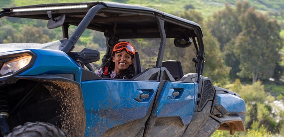 Woman driving blue side-by-side in the great outdoors.