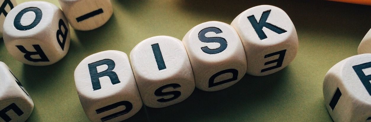 Dice spelling out the word "RISK".