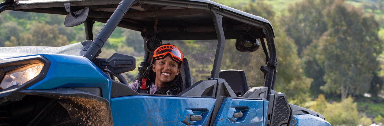 Woman driving blue side-by-side in the great outdoors.