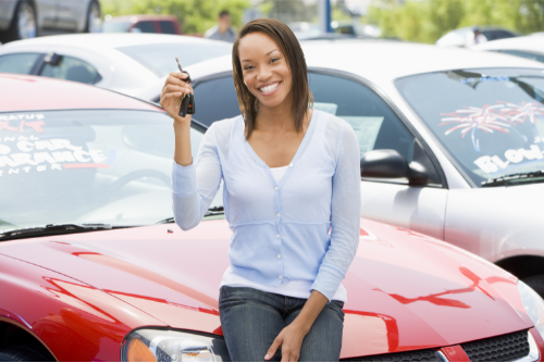 A young woman holds up the keys to a new car purchased with a vehicle loan from Pilot Grove Savings Bank.