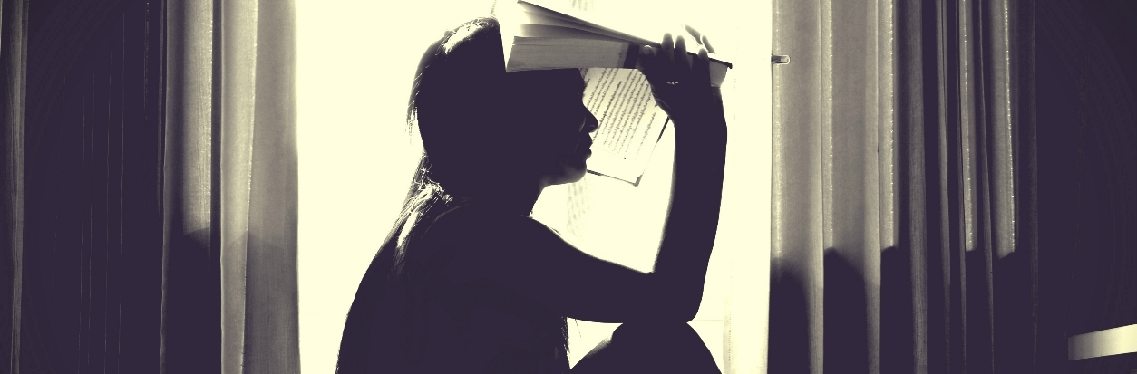 Silhouette of person with book on their head